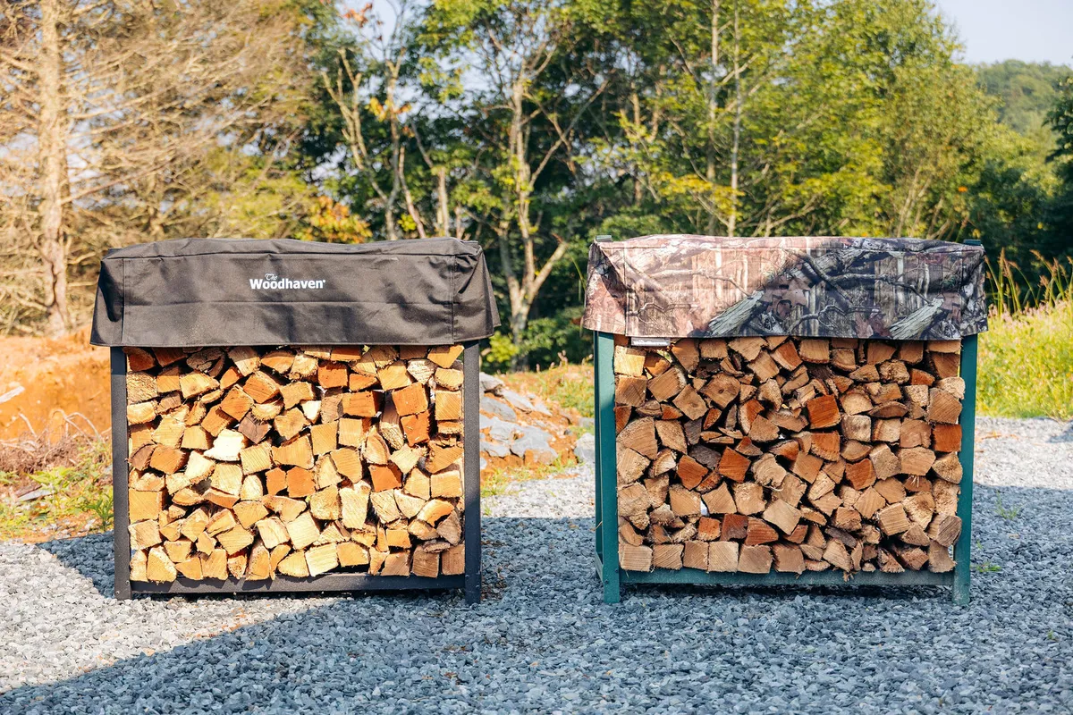 Two filled Linville River Company firewood racks side by side â one black with a black cover, one forest green with a camo cover
